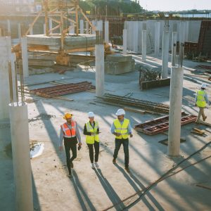 Diverse Team of Specialists Taking a Walk Through Construction Site. Real Estate Building Project with Senior Civil Engineer, Architect, General Worker Discussing Planning and Development Details.